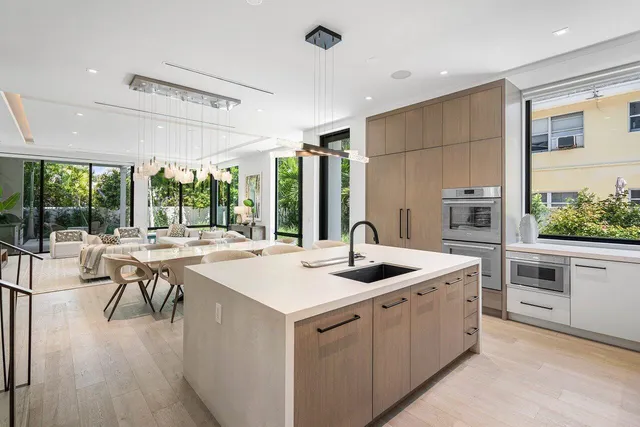 a kitchen that has a sink a stove and a table with chairs in it