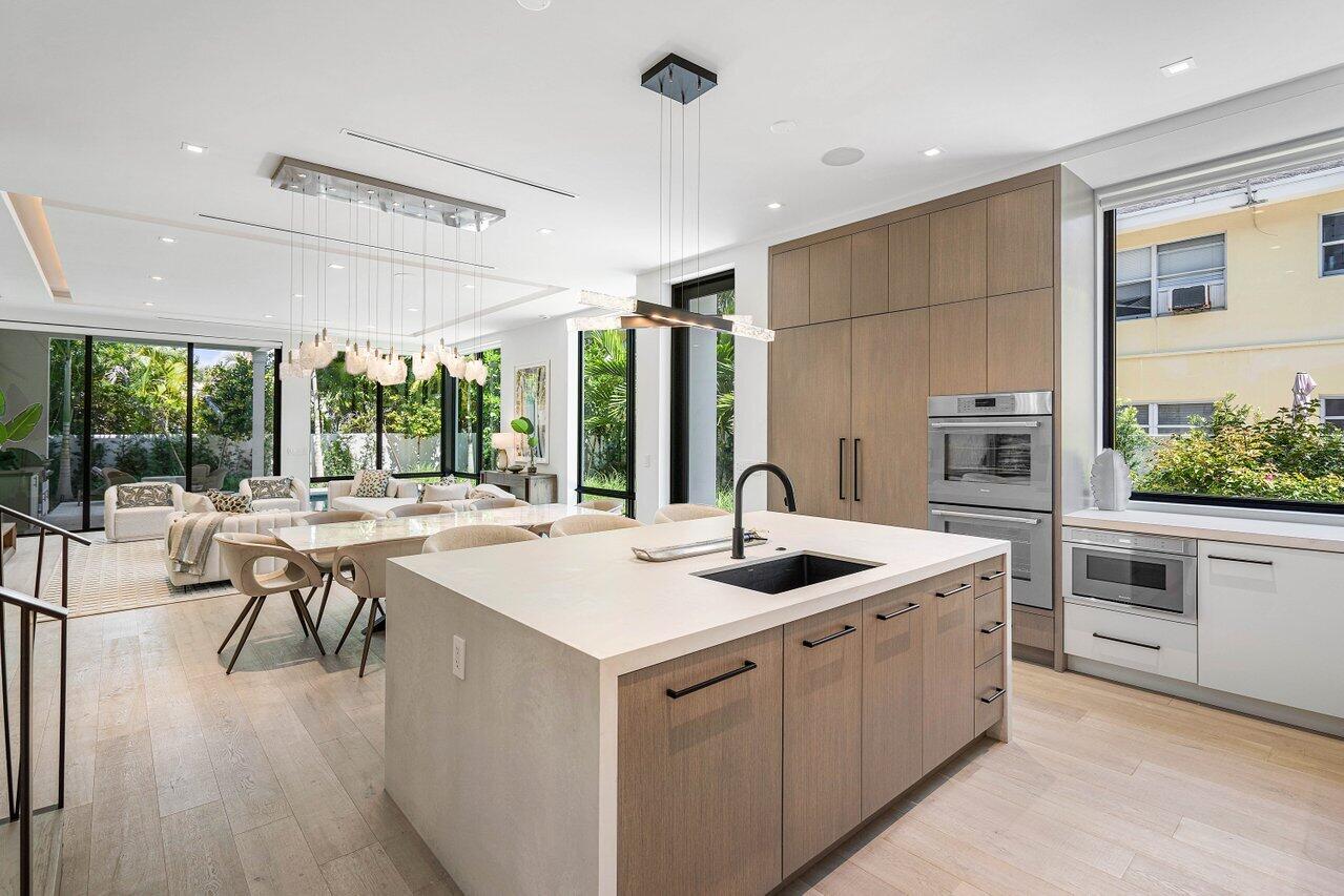 514 Northeast 7th Avenue Delray Beach, FL 33483 - Photo 10 of 51 a kitchen that has a sink a stove and a table with chairs in it