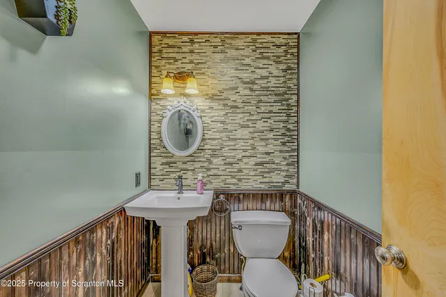 a bathroom with a toilet a sink and a mirror