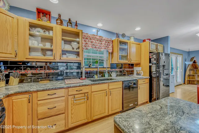 a kitchen with stainless steel appliances granite countertop a sink and cabinets