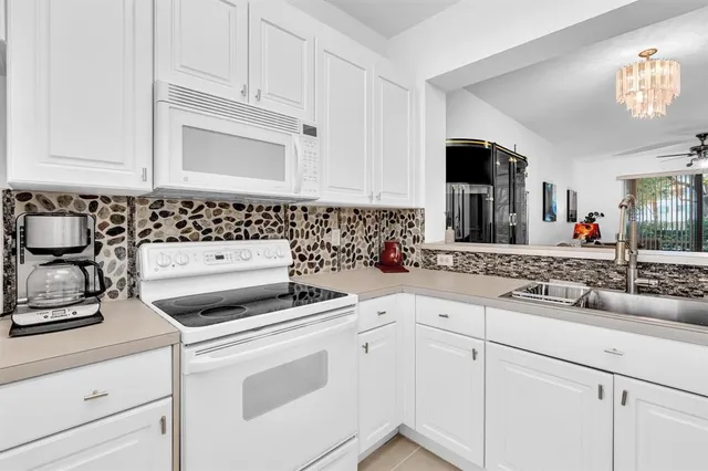 a living room with furniture kitchen view and a flat screen tv