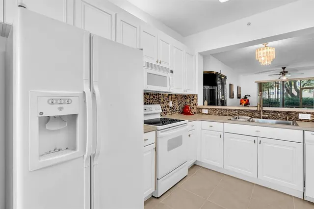 a kitchen with white cabinets and appliances