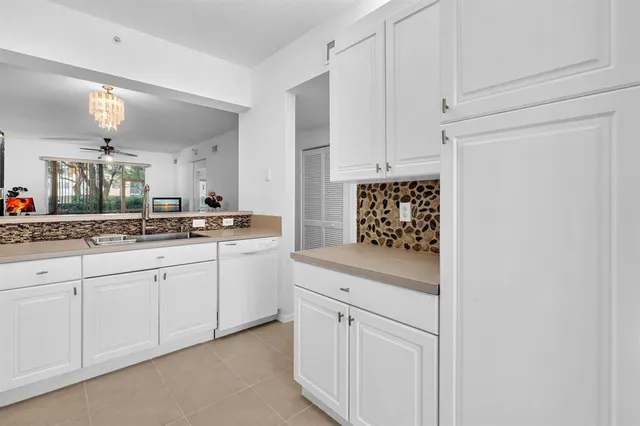 a kitchen with white cabinets and white appliances
