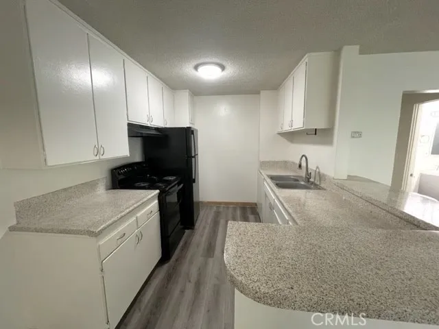 a kitchen with granite countertop a sink stainless steel appliances and cabinets