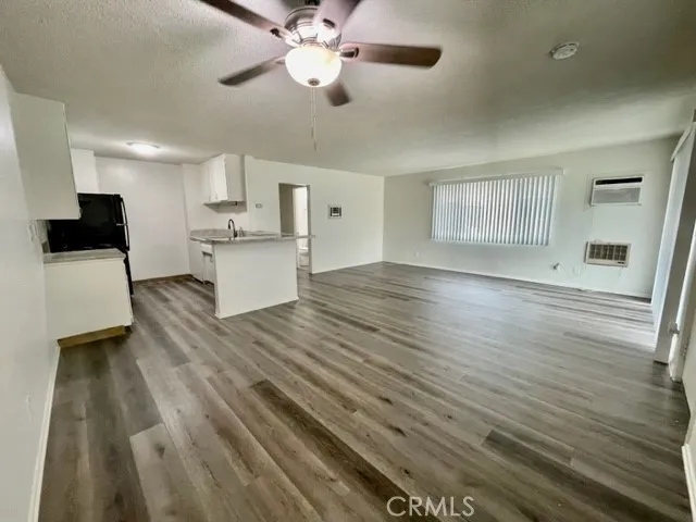 a view of a kitchen with wooden floor and a ceiling fan