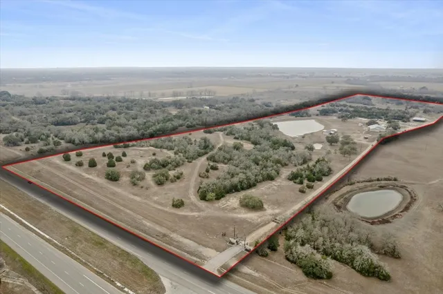 an aerial view of a house with a yard and lake view