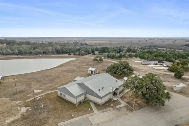 an aerial view of a house with a yard and lake view