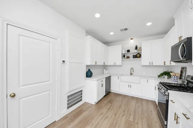 a kitchen with a sink a stove and cabinets