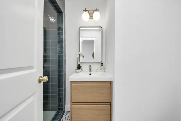 a bathroom with a sink a shower and a mirror