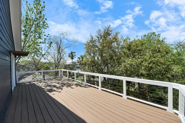 a view of backyard with wooden floor and potted plants