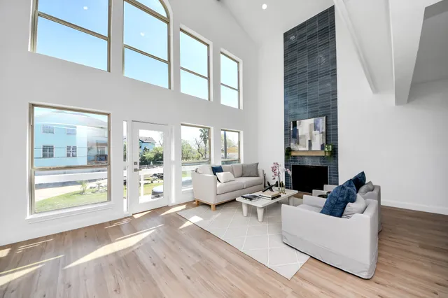 a living room with fireplace furniture and a large window