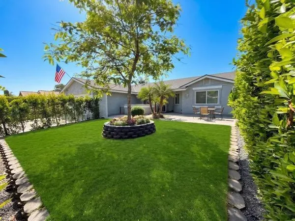 a view of a house with backyard sitting area and garden