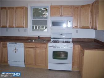 211 Dickinson Road Glassboro, NJ 08028 - Photo 5 of 10 a kitchen with granite countertop white cabinets and white stove