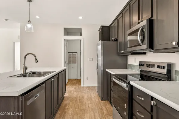a kitchen with stainless steel appliances granite countertop a sink stove and refrigerator