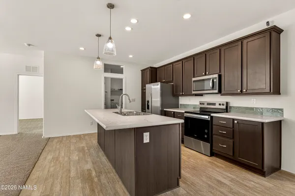 a kitchen with stainless steel appliances granite countertop a sink stove and refrigerator