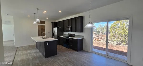 a kitchen with stainless steel appliances granite countertop a stove a sink and a microwave