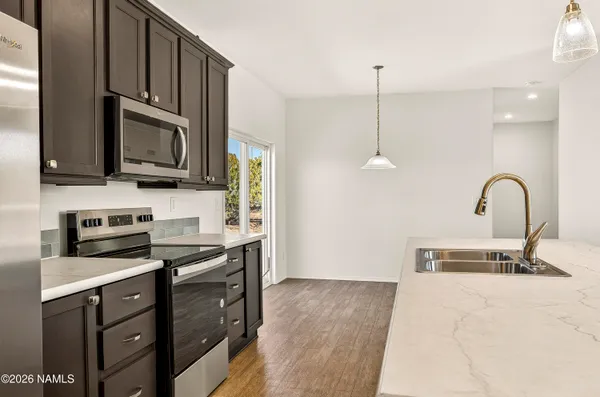 a kitchen with kitchen island granite countertop a sink counter space and a refrigerator