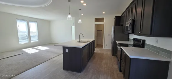 a view of kitchen with kitchen island a sink stainless steel appliances and cabinets
