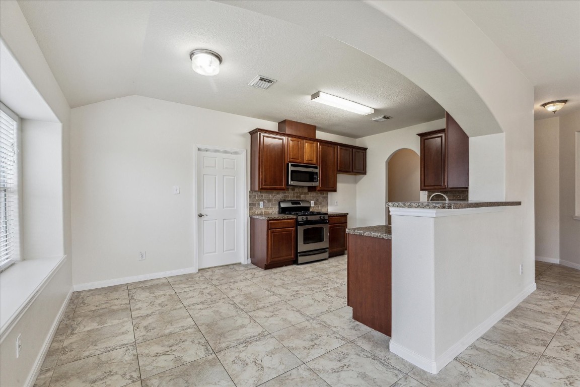 1805 Clover Patch Alvin, TX 77511 - Photo 6 of 14 a kitchen with stainless steel appliances a microwave sink stove and refrigerator