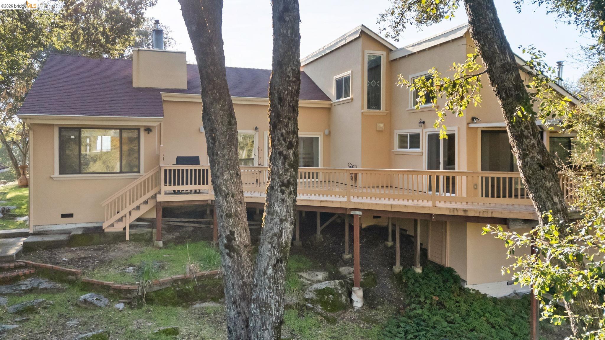 21916 Phoenix Lake Road Sonora, CA 95370 - Photo 41 of 48 a view of a white house with large windows and a small yard