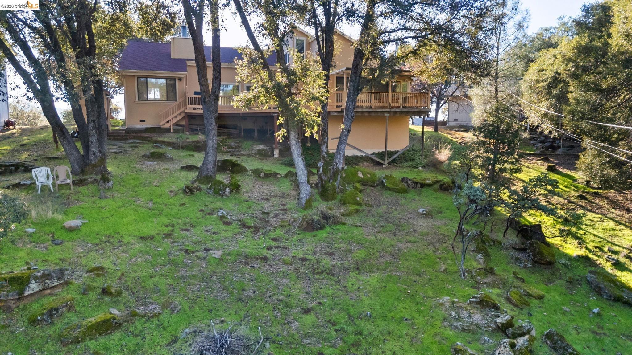 21916 Phoenix Lake Road Sonora, CA 95370 - Photo 43 of 48 a view of a brick house next to a yard with a tree