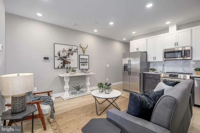 a living room with furniture and a view of kitchen