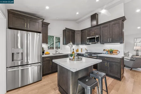 a kitchen with stainless steel appliances granite countertop a refrigerator and a sink