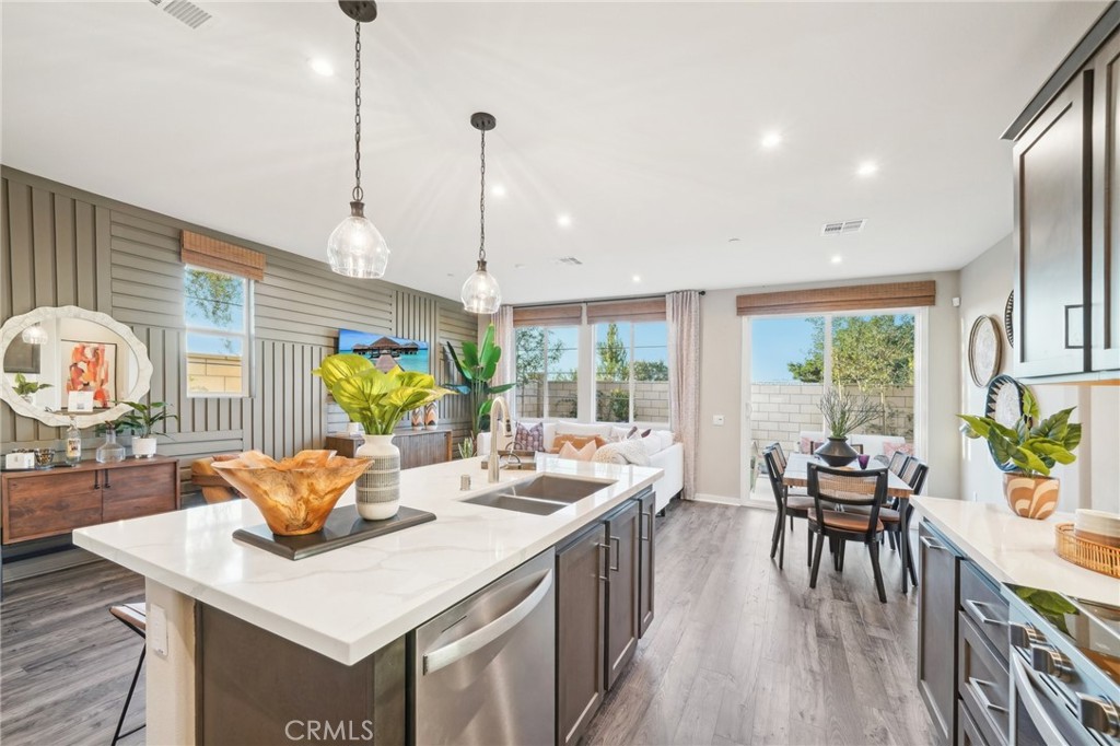 16051 Montenegro Lane Fontana, CA 92336 - Photo 4 of 17 a view of a dining room and livingroom with furniture wooden floor a chandelier