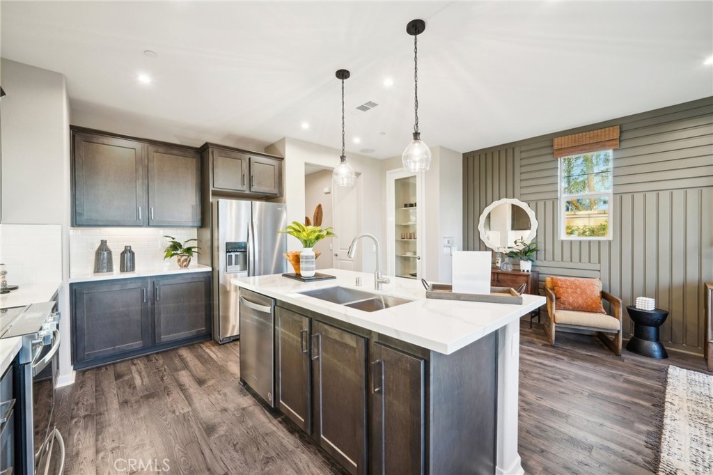 16051 Montenegro Lane Fontana, CA 92336 - Photo 5 of 17 a kitchen with a sink stove and wooden floor