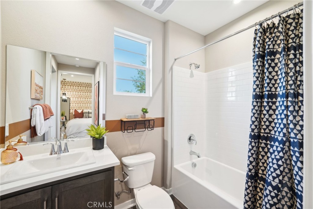 16051 Montenegro Lane Fontana, CA 92336 - Photo 7 of 17 a bathroom with a bathtub a sink a toilet a mirror and shower