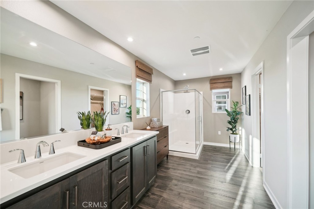 16051 Montenegro Lane Fontana, CA 92336 - Photo 10 of 17 a spacious bathroom with a double vanity sink and a mirror