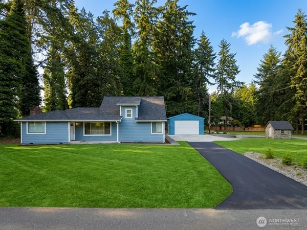a front view of a house with a yard and trees