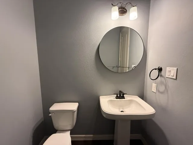 a bathroom with a toilet sink and mirror