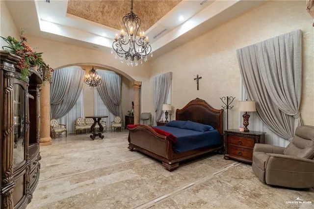 a spacious bedroom with bed and a chandelier