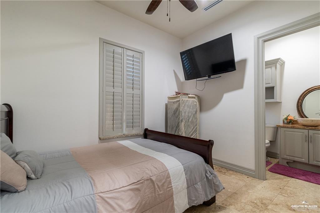 1205 Travis Street Mission, TX 78572 - Photo 19 of 45 a bedroom with a bed and a flat tv screen on the dresser
