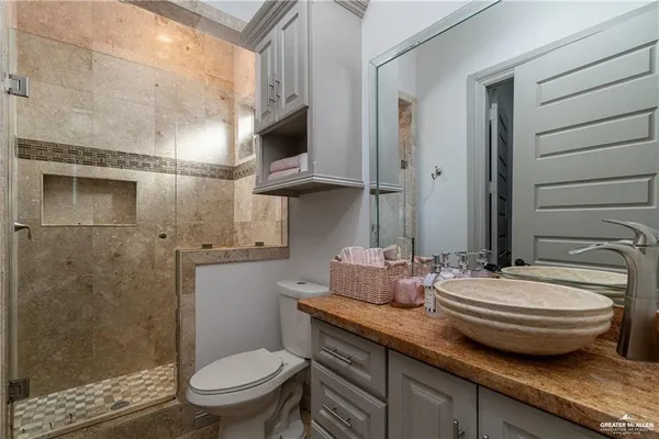 a bathroom with a granite countertop sink a toilet and a mirror