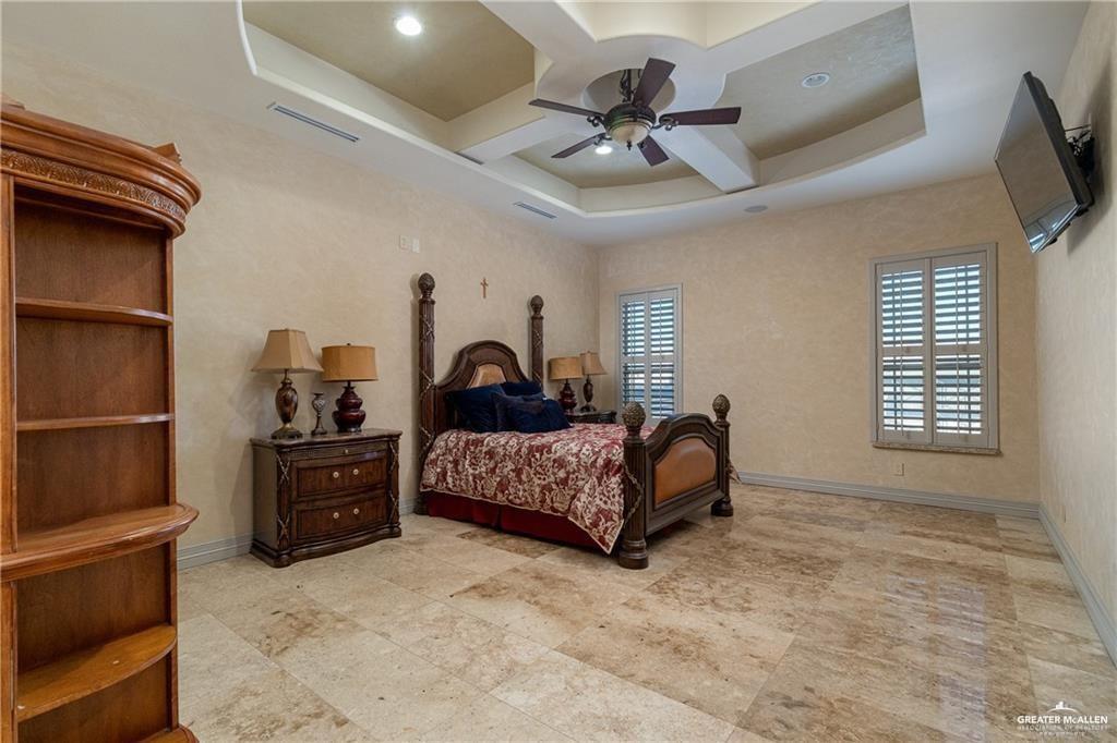1205 Travis Street Mission, TX 78572 - Photo 30 of 45 a bedroom with a bed and a chandelier