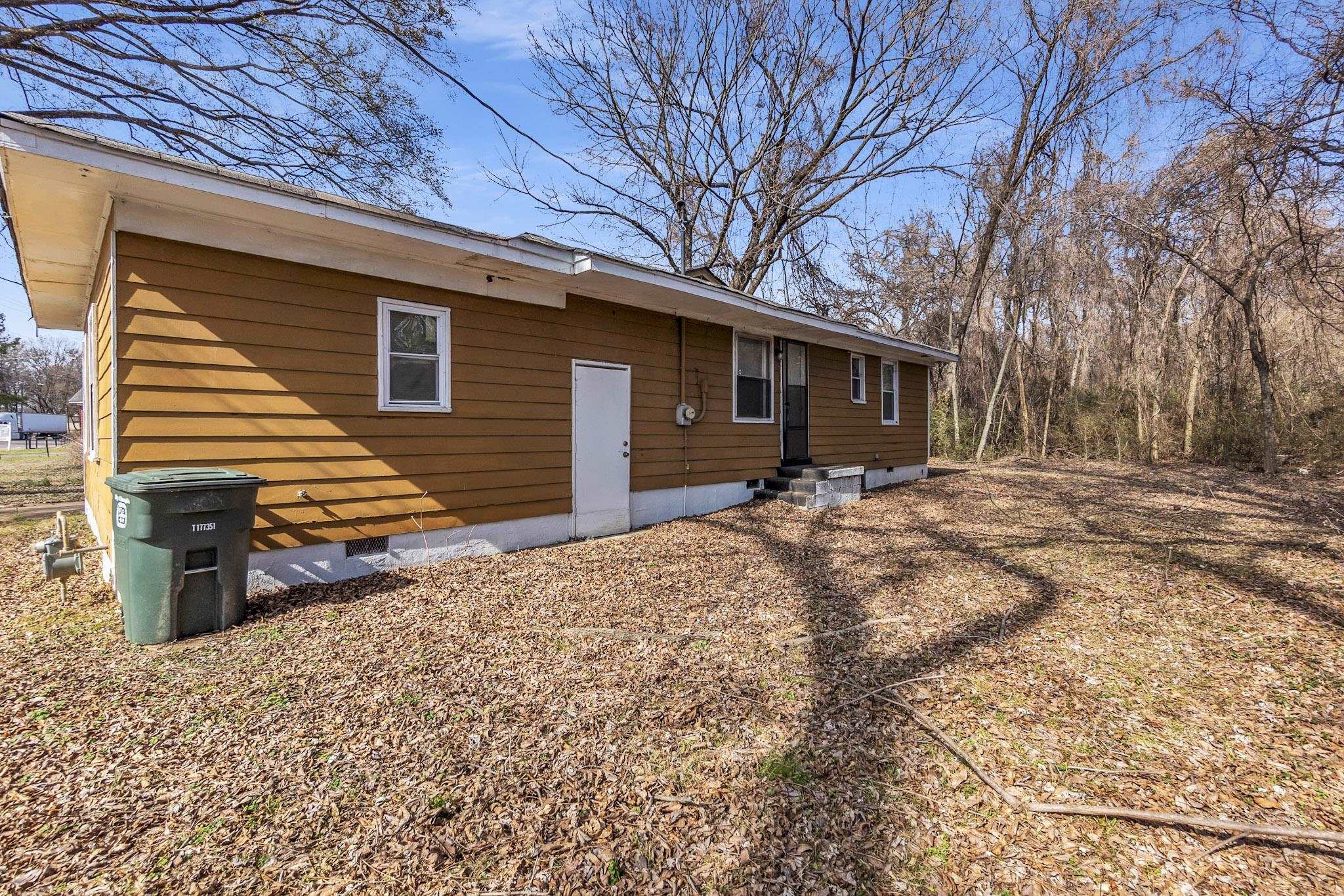 2196 Ketchum Road Memphis, TN 38114 - Photo 20 of 20 a backyard of a house with large trees and covered by side of it