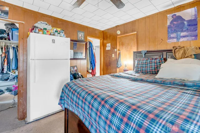 a bedroom with a bed and a refrigerator