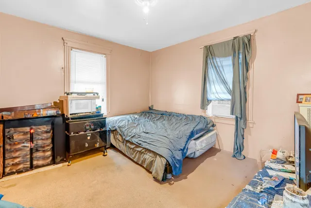 a bedroom with a bed and dresser with mirror