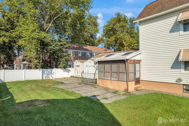 a view of a white house that has a yard