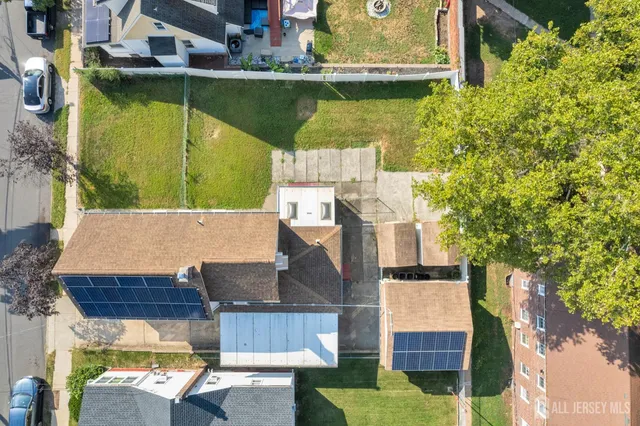 an aerial view of a house with swimming pool and large trees