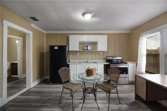 a kitchen with a table chairs and a refrigerator