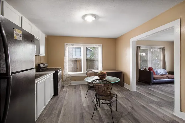 a kitchen with a refrigerator and chairs