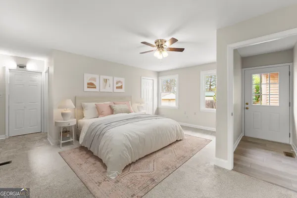 a spacious bedroom with a large bed and a chandelier