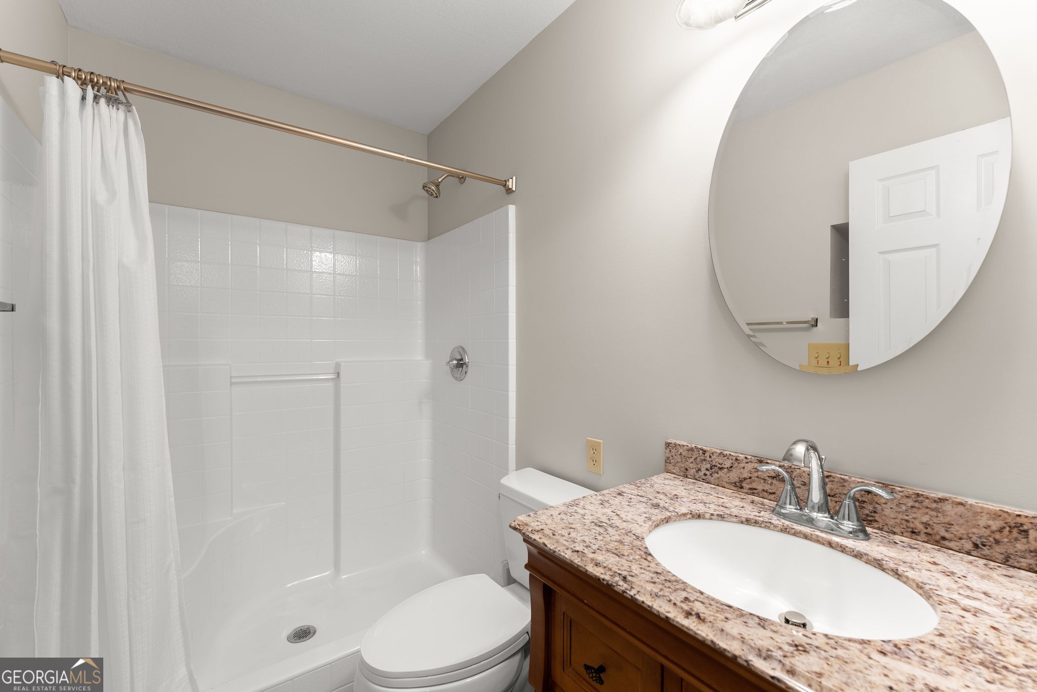 1292 Fernside Drive Toccoa, GA 30577 - Photo 19 of 42 a bathroom with a granite countertop sink toilet a mirror and shower