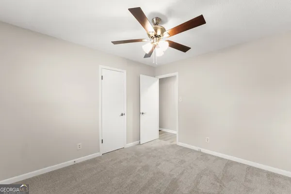 an empty room with wooden floor and a ceiling fan