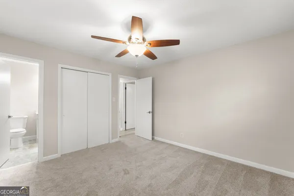 a view of a room with a ceiling fan and a bathroom