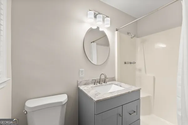 a bathroom with a sink vanity mirror and toilet