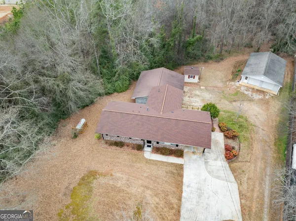 a view of a house with a backyard and trees
